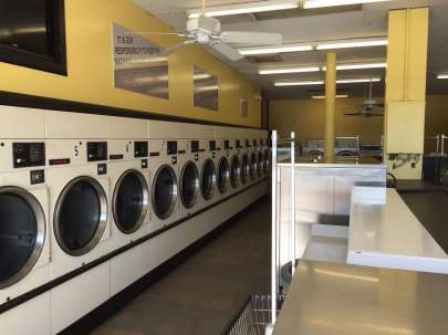 Okeechobee location. Washers along the wall, counter, clean yellow interior, ceiling fans.